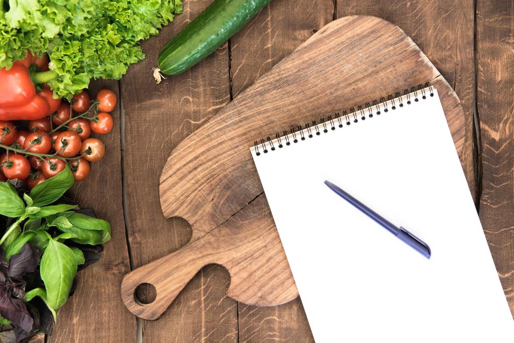 Notizblock mit rohem Gemüse auf dem Tisch - Foto, Bild