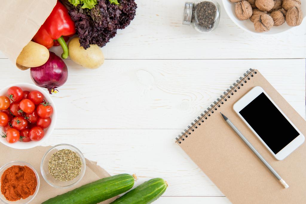 Smartphone και λαχανικά στο τραπέζι  - Φωτογραφία, εικόνα