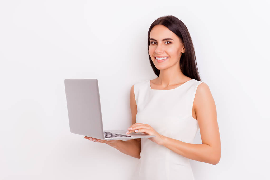 Młody uśmiechający się atrakcyjny brunetka dziewczyna trzyma laptopa i typ - Zdjęcie, obraz
