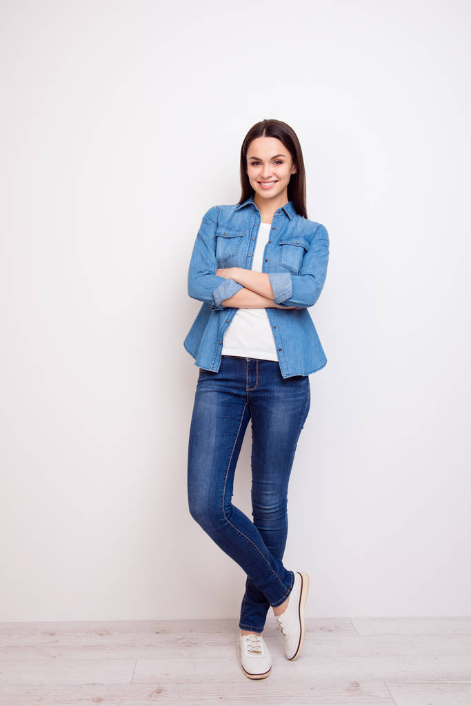 Pretty young woman in jeans and shirt standing with crossed hand - Photo, Image