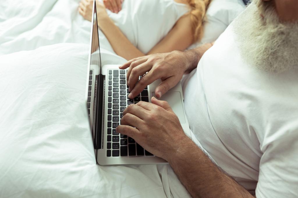 Felnőtt pár az ágyban laptoppal  - Fotó, kép