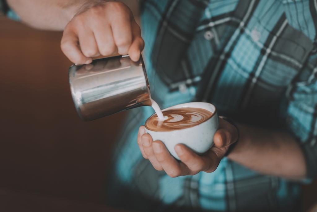 бариста вливає молоко в каву
 - Фото, зображення