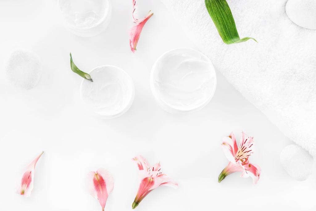 Λουλούδια και κρέμα γάλακτος σε δοχεία  - Φωτογραφία, εικόνα