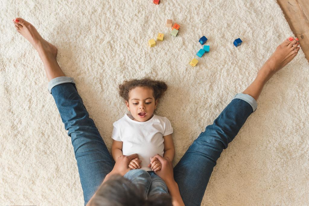 dziecko dziewczynka bawi się z matką na dywanie - Zdjęcie, obraz