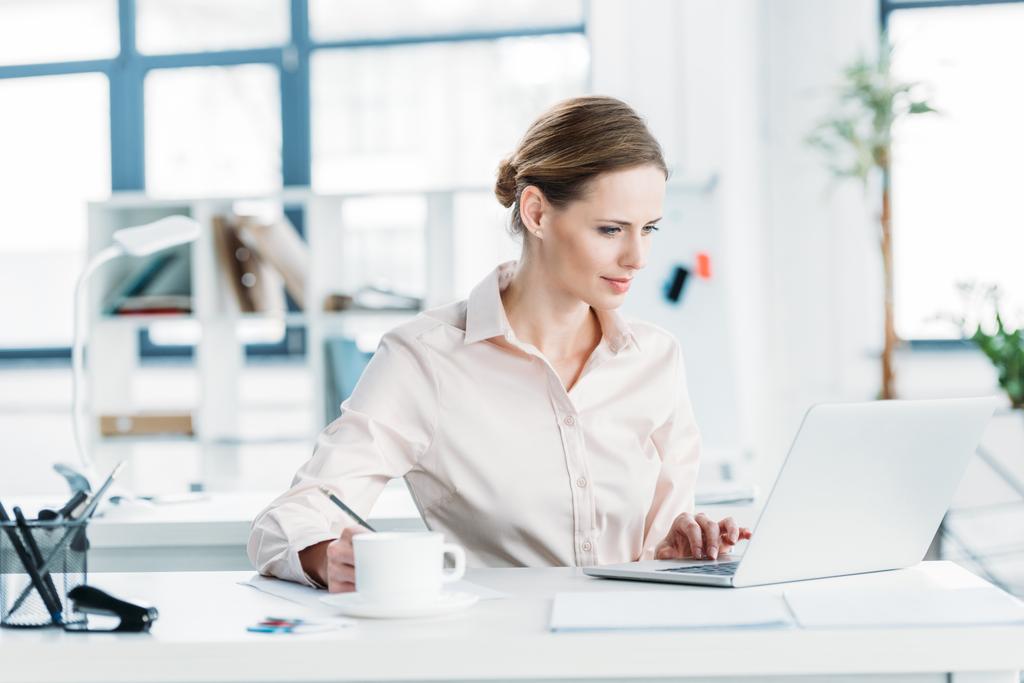 Bizneswoman pracuje na laptopie w biurze - Zdjęcie, obraz