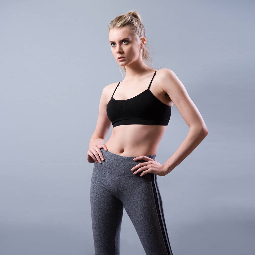 Gyönyörű fiatal fitness nő sport ruhában pózol - Fotó, kép