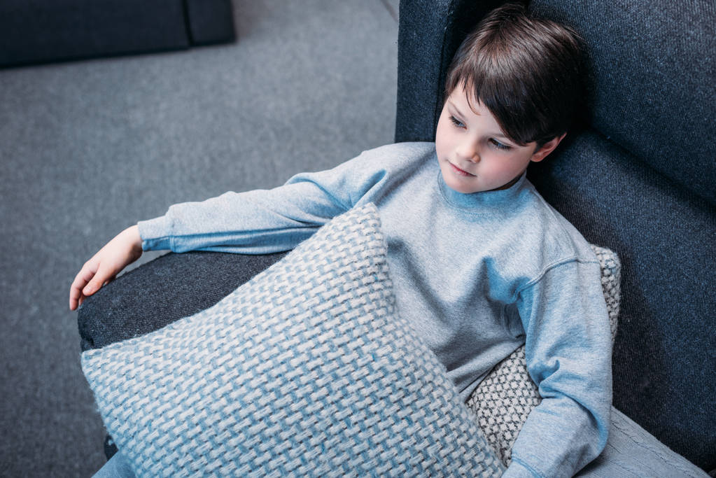 Garçon en pyjama sur canapé
  - Photo, image