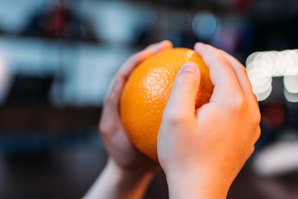 niña sosteniendo naranja madura
 - Foto, Imagen