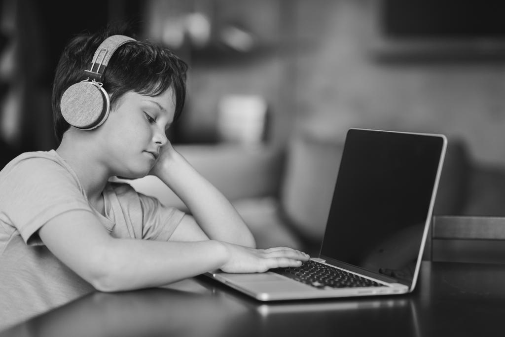 garoto menino em fones de ouvido digitando no laptop
 - Foto, Imagem
