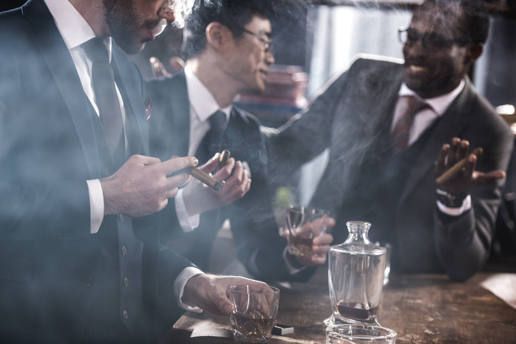 équipe d'affaires multiculturelle passer du temps, fumer des cigares et boire du whisky
 - Photo, image