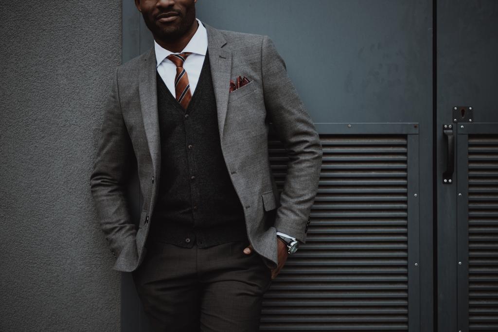 confiante elegante empresário afro-americano posando ao ar livre na parede
 - Foto, Imagem