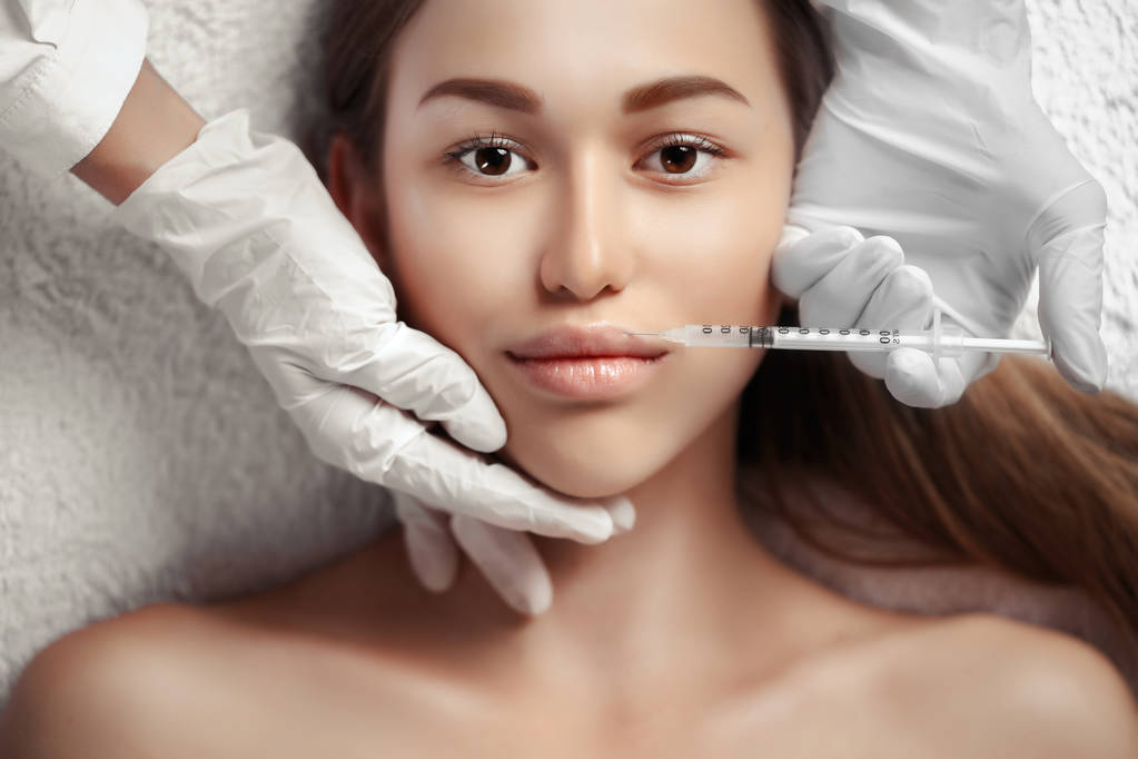 Retrato de mujer recibiendo inyección cosmética
 - Foto, imagen
