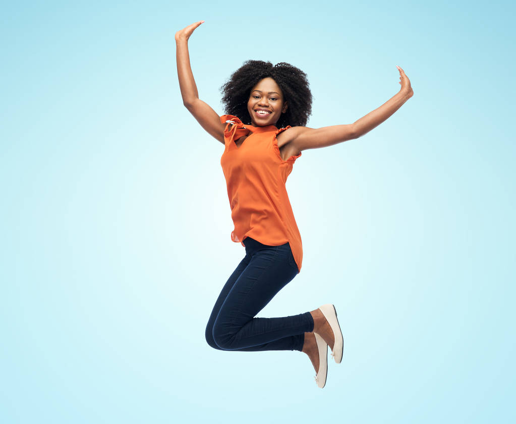 feliz afro-americana mulher saltando sobre branco - Foto, Imagem