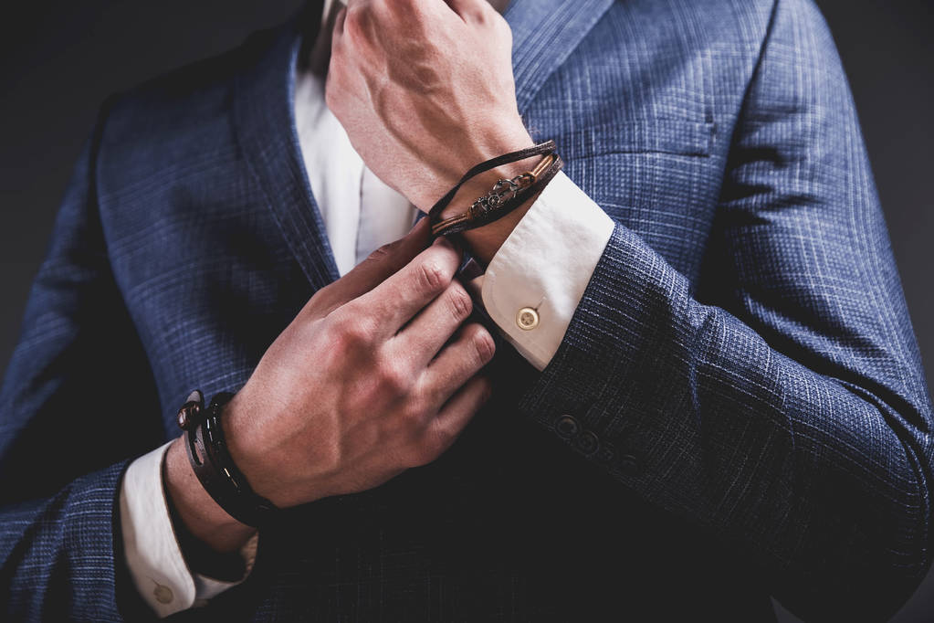 joven hombre de negocios guapo modelo hombre vestido con elegante traje azul con accesorios en las manos
  - Foto, imagen
