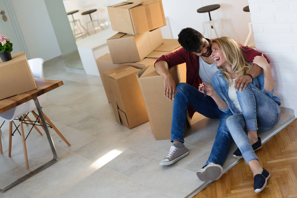 Giovane coppia felice trasferirsi in una nuova casa e disimballaggio scatole
 - Foto, immagini