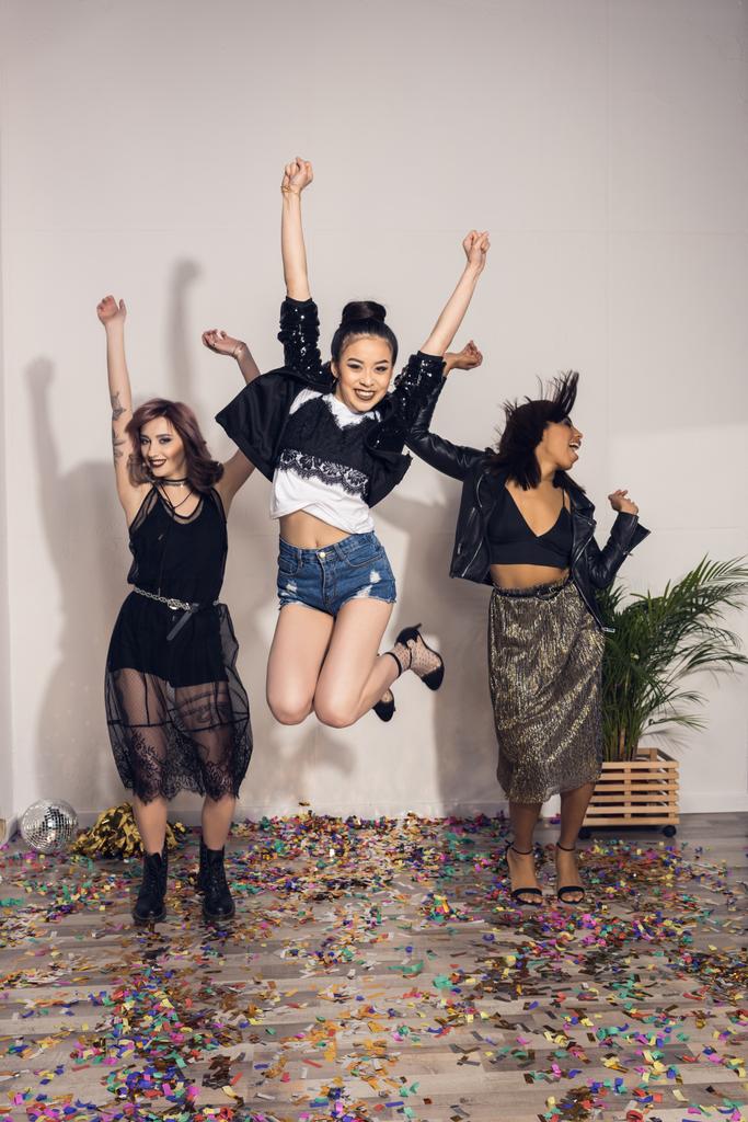 iloinen monikansallinen tytöt hyppäämällä juhlissa
 - Valokuva, kuva