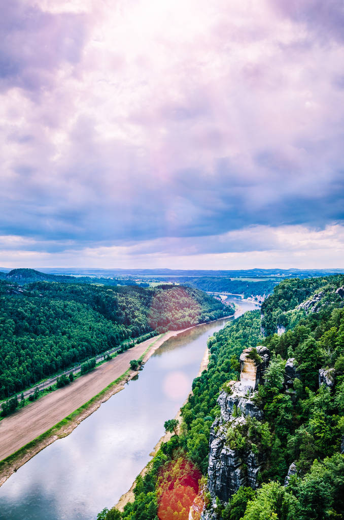 View from the Bastei to the river Elbe in Saxon Switzerland. Sun flares coming through the clouds. Dresden. Germany - Photo, Image
