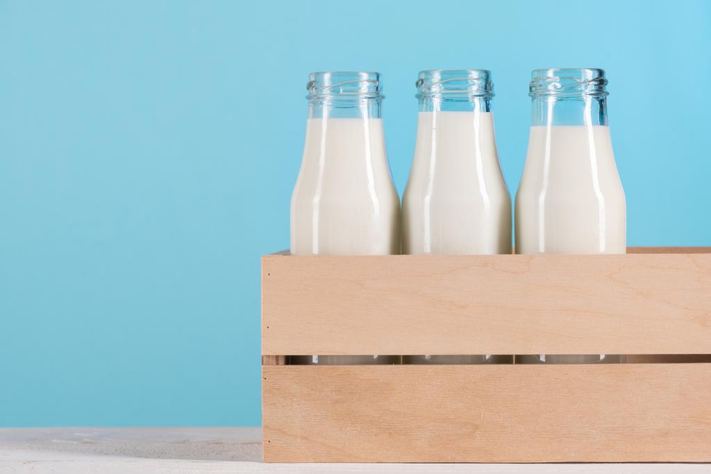 szklane butelki z mlekiem w drewniane pudełko - Zdjęcie, obraz