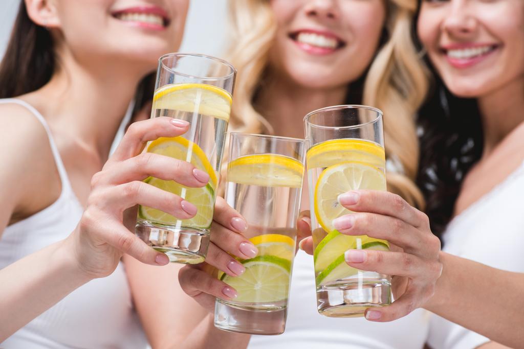 mujeres tintineo con vasos de agua con limón
 - Foto, Imagen