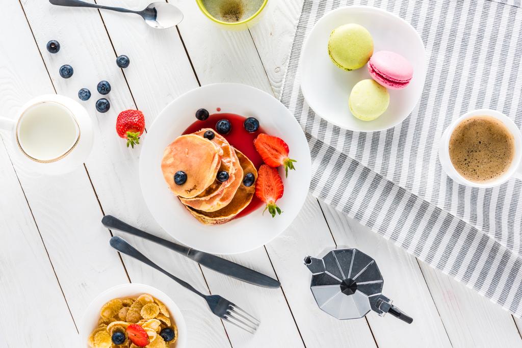 Pfannkuchen mit Macarons und Kaffee auf Holztischplatte - Foto, Bild