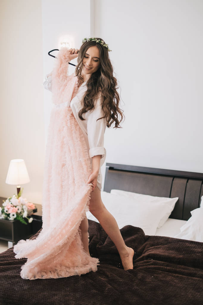 γυναίκα με φόρεμα στέκεται στο κρεβάτι  - Φωτογραφία, εικόνα