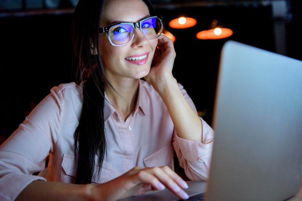 businesswoman working on laptop and looking at camera - Photo, Image