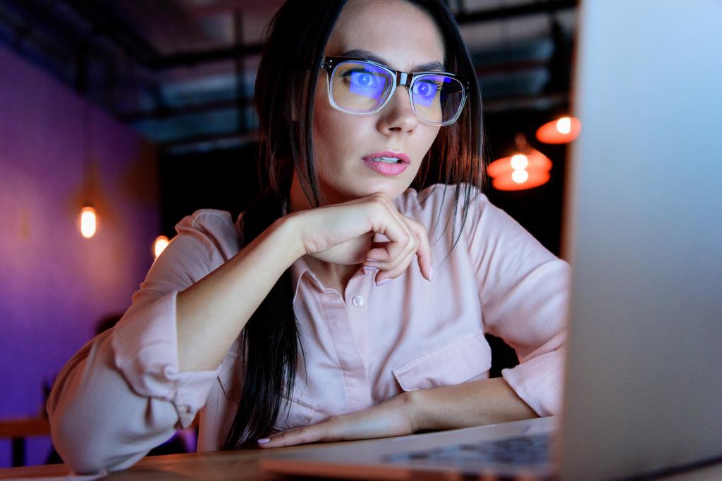 Кавказская деловая женщина в очках, глядя на ноутбук
 - Фото, изображение