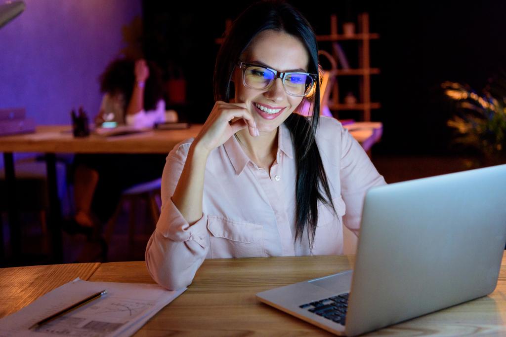 uśmiecha się kobieta interesu w okulary praca na laptopie - Zdjęcie, obraz