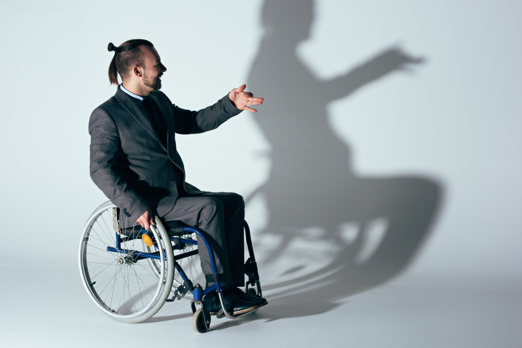 車椅子犬の影を作るビジネスマン - 写真・画像