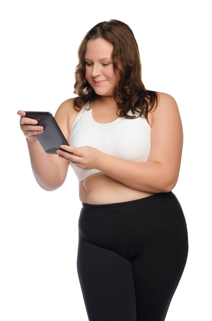 Lachende dikke sportieve vrouw met tablet - Foto, afbeelding