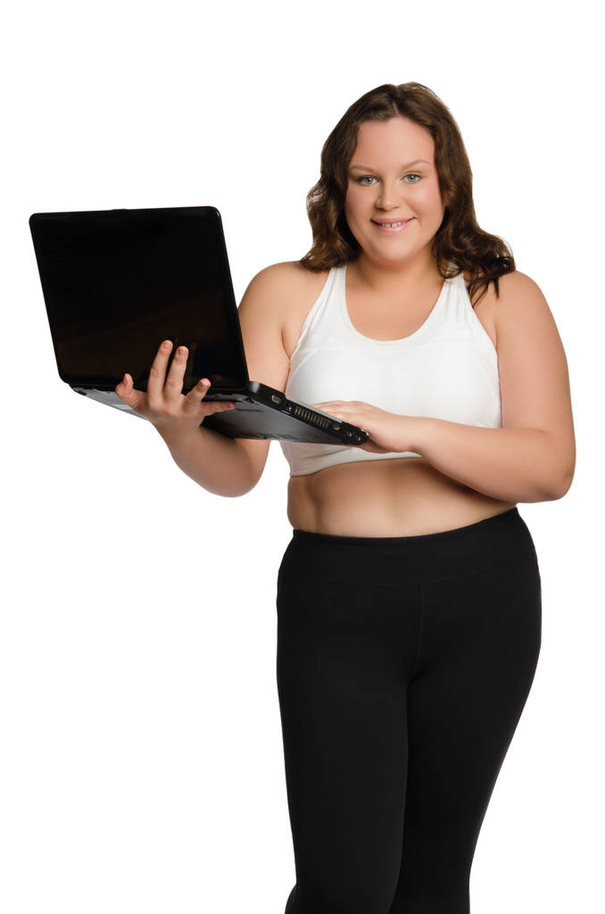 ノート パソコンと脂肪のスポーティな女性の笑みを浮かべてください。 - 写真・画像