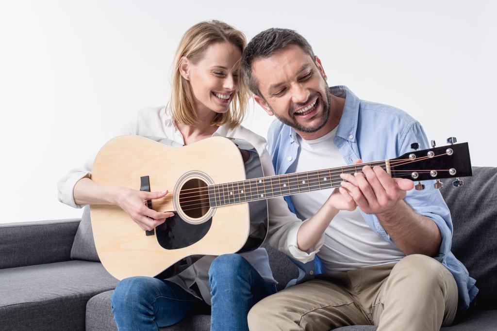 mężczyzna nauczanie kobieta gra na gitarze - Zdjęcie, obraz