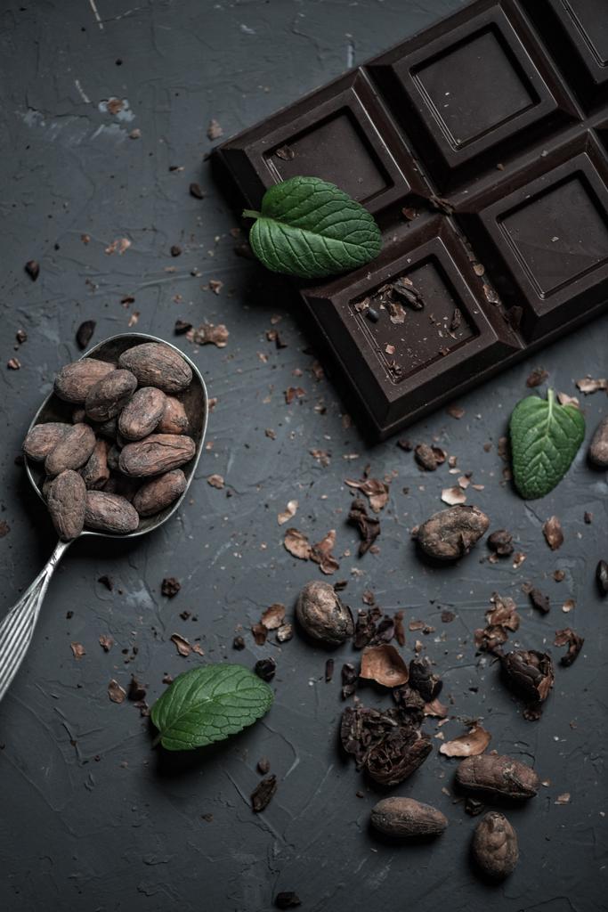 Schokoriegel und Löffel mit Kakaobohnen - Foto, Bild