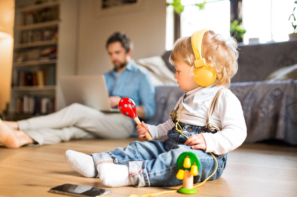 Pai e filho com smartphone, fones de ouvido e laptop
. - Foto, Imagem