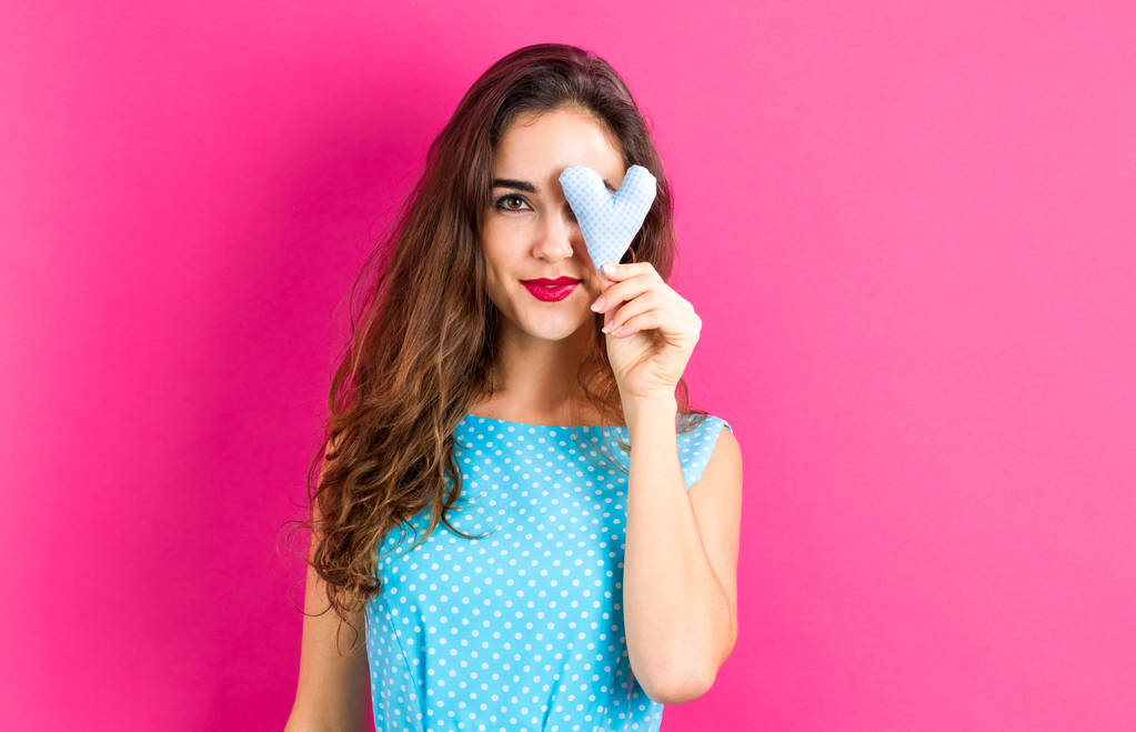 young woman holding a heart cushion - Photo, Image