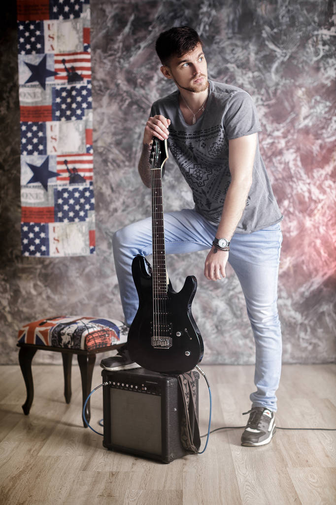 Genç yakışıklı müzisyen elektro gitar koyu arka plan üzerinde ile - Fotoğraf, Görsel
