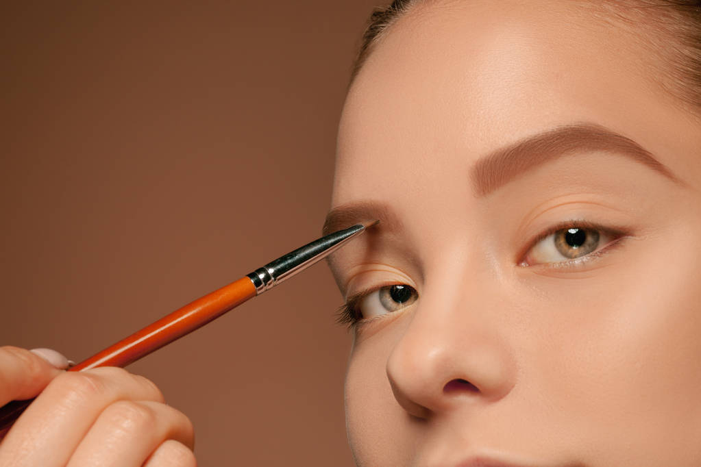Lindos olhos femininos com maquiagem e escova
 - Foto, Imagem