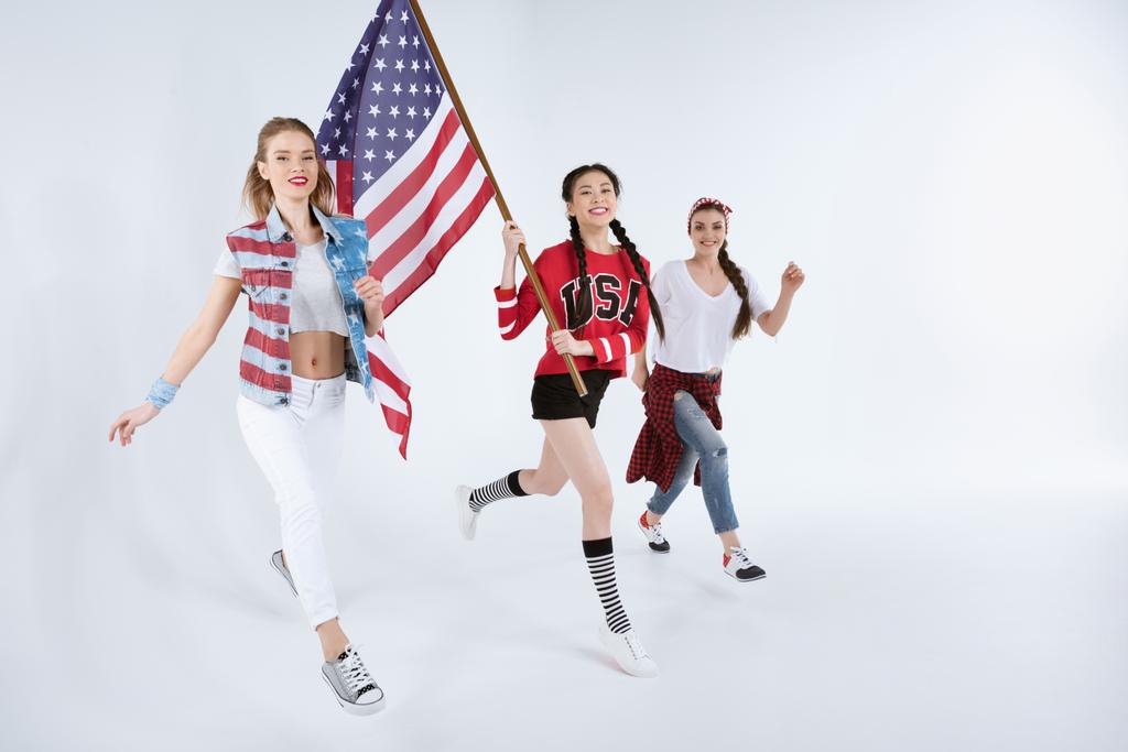 mujeres multiétnicas caminando con bandera americana
 - Foto, imagen