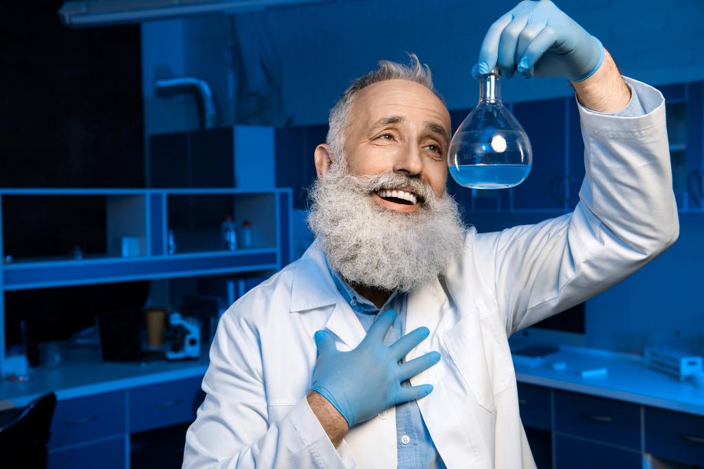 grey haired scientist holding flask - Photo, Image