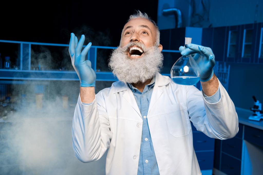 зрелый ученый держит фляжку
 - Фото, изображение