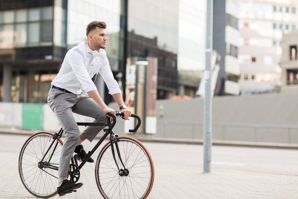 Muž se sluchátky jezdit kole na městské ulici - Fotografie, Obrázek