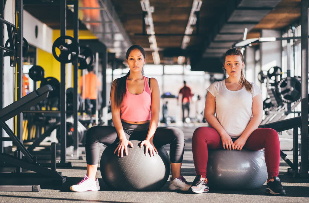Deux jeunes filles en bonne santé avec des balles de pilates ou de gymnastique prenant une pause de leur séance d'entraînement dans la salle de gym
 - Photo, image