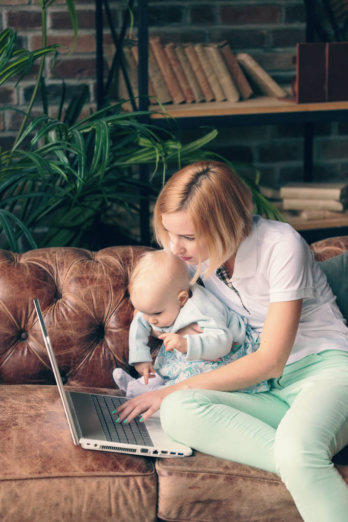 junge Mutter arbeitet zu Hause mit Baby-Mädchen - Foto, Bild