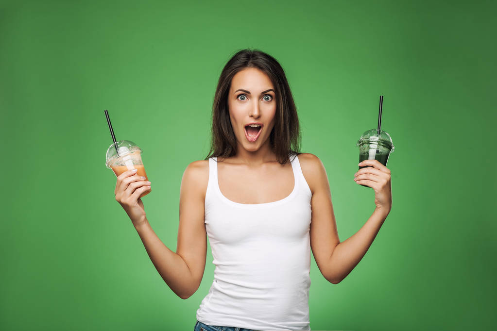Joven mujer sorprendida sosteniendo smoothie
 - Foto, Imagen