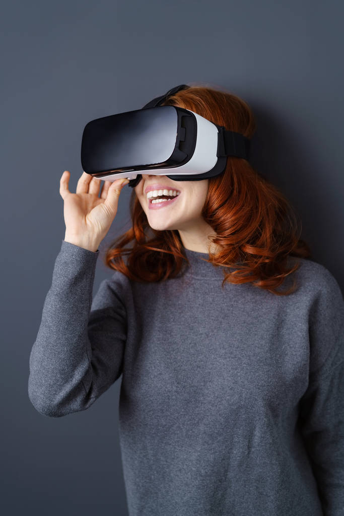 仮想現実のヘッドセットを使用して快活な女性 - 写真・画像