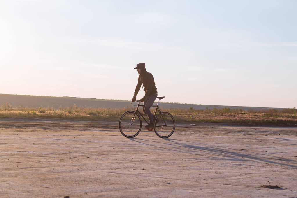 Sám jezdec na pevné zařízení silniční kolo v poušti poblíž řeky, bokovky turistické kolo rider obrázky. - Fotografie, Obrázek