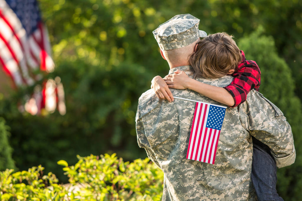 Amerikaanse soldaat herenigd met zoon op een zonnige dag  - Foto, afbeelding