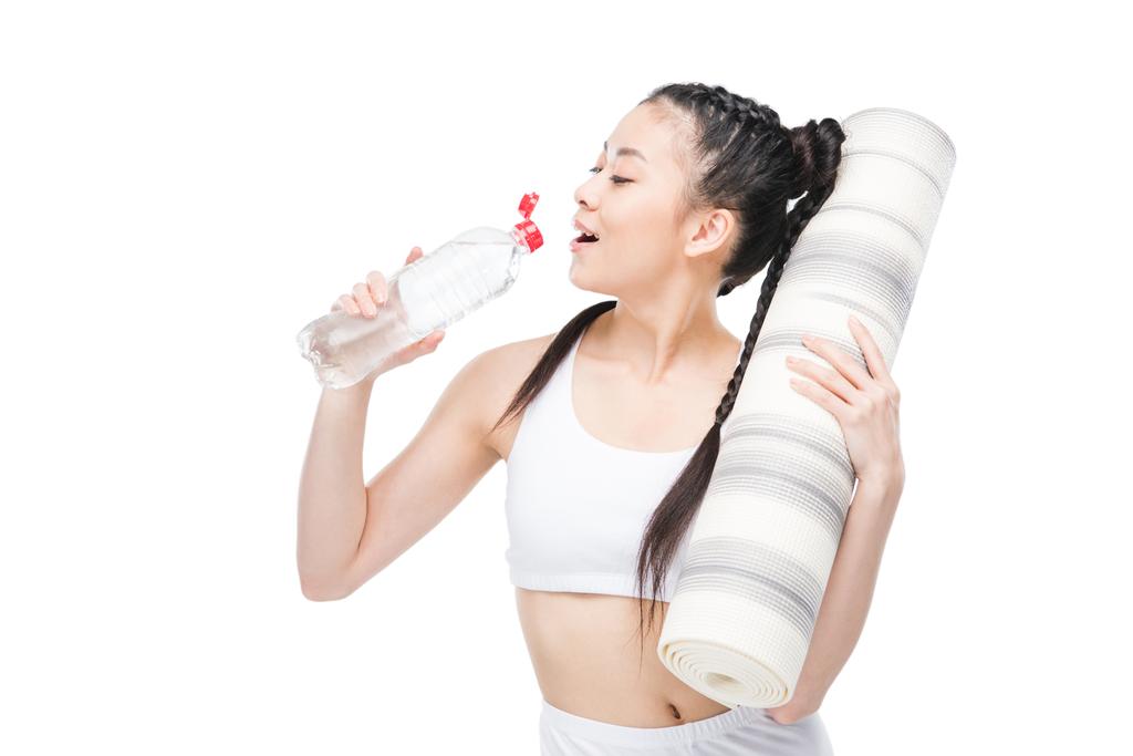 Chica con estera de yoga agua potable
  - Foto, imagen