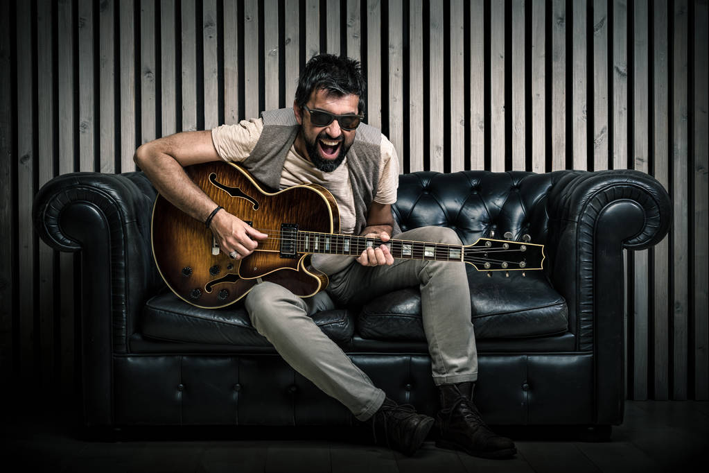 портрет гитариста, играющего на электрогитаре
  - Фото, изображение