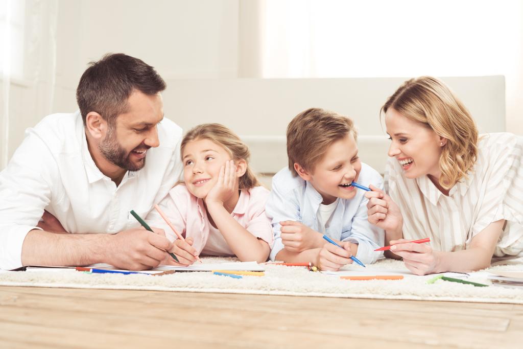 Ευτυχισμένη οικογένεια ζωγραφίζει εικόνες στο σπίτι - Φωτογραφία, εικόνα